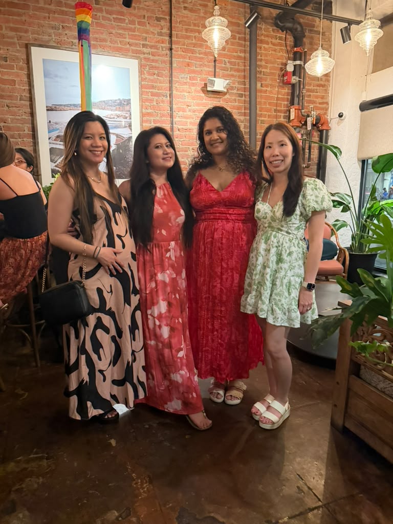 Kat with three friends at a brick-walled restaurant