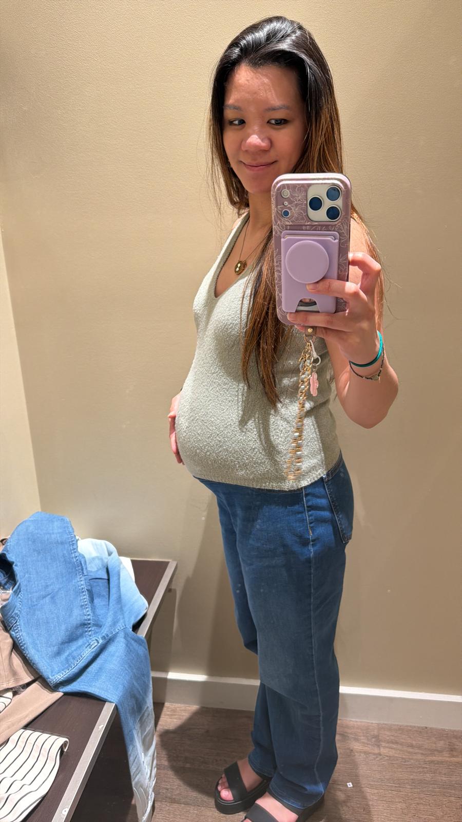 Kat showing her baby bump in a mirror